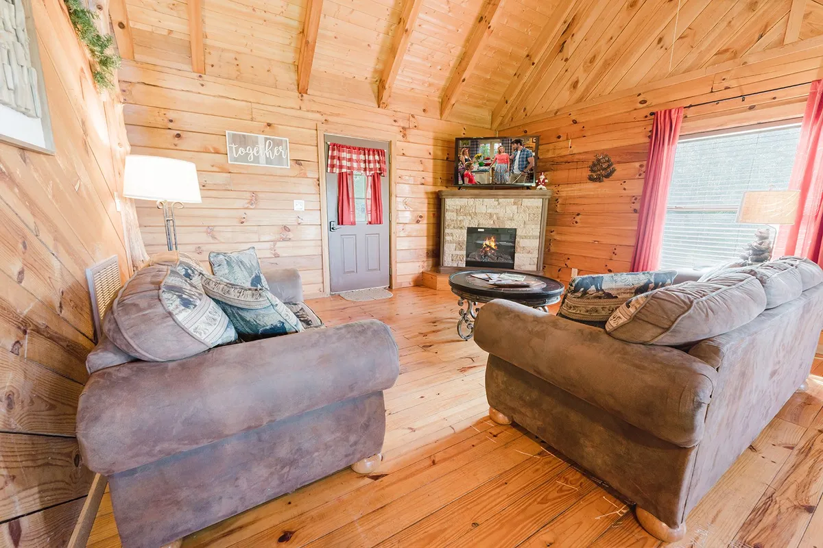 A close-up view of the living area, focusing on an inviting sofa, the electric fireplace, and a window adorned with decorative touches. The ambiance is cozy, perfect for curling up with a book or sharing stories with loved ones.